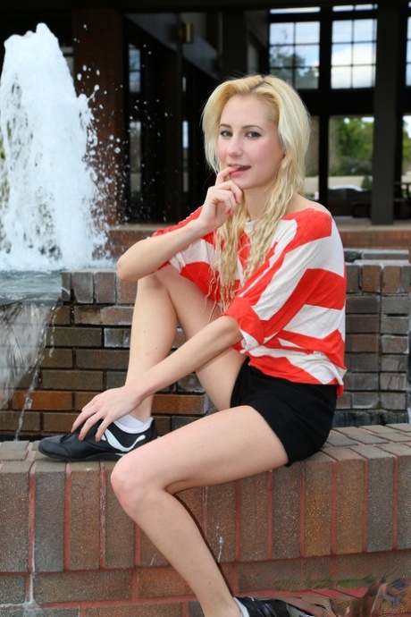 Blonde Odette Delacroix shows her tiny tits while giving a handjob outdoors