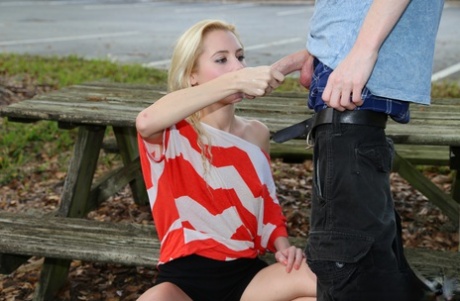 Blonde Odette Delacroix shows her tiny tits while giving a handjob outdoors